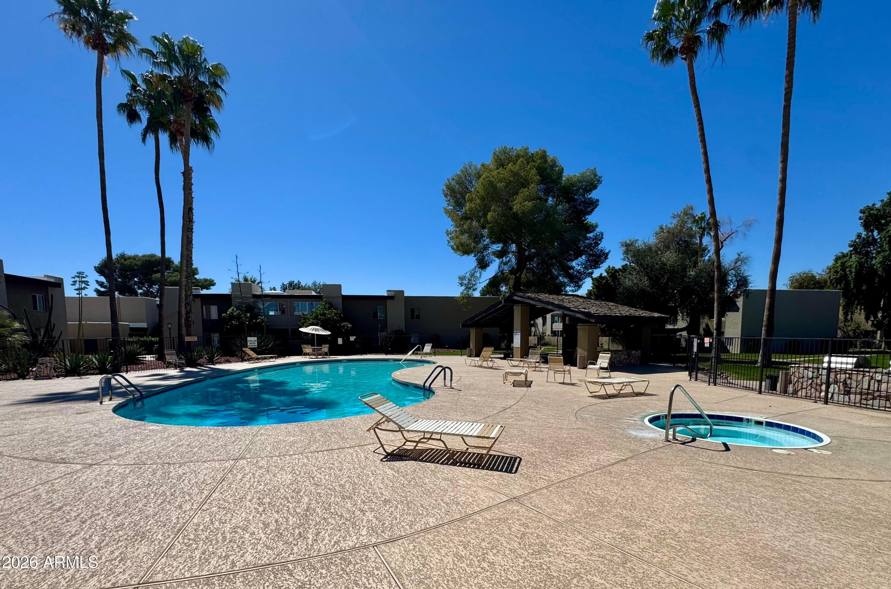 4201 East Camelback Road, Unit 18 Phoenix, AZ 85018 - Photo 3 of 4 a view of swimming pool with a table and chairs