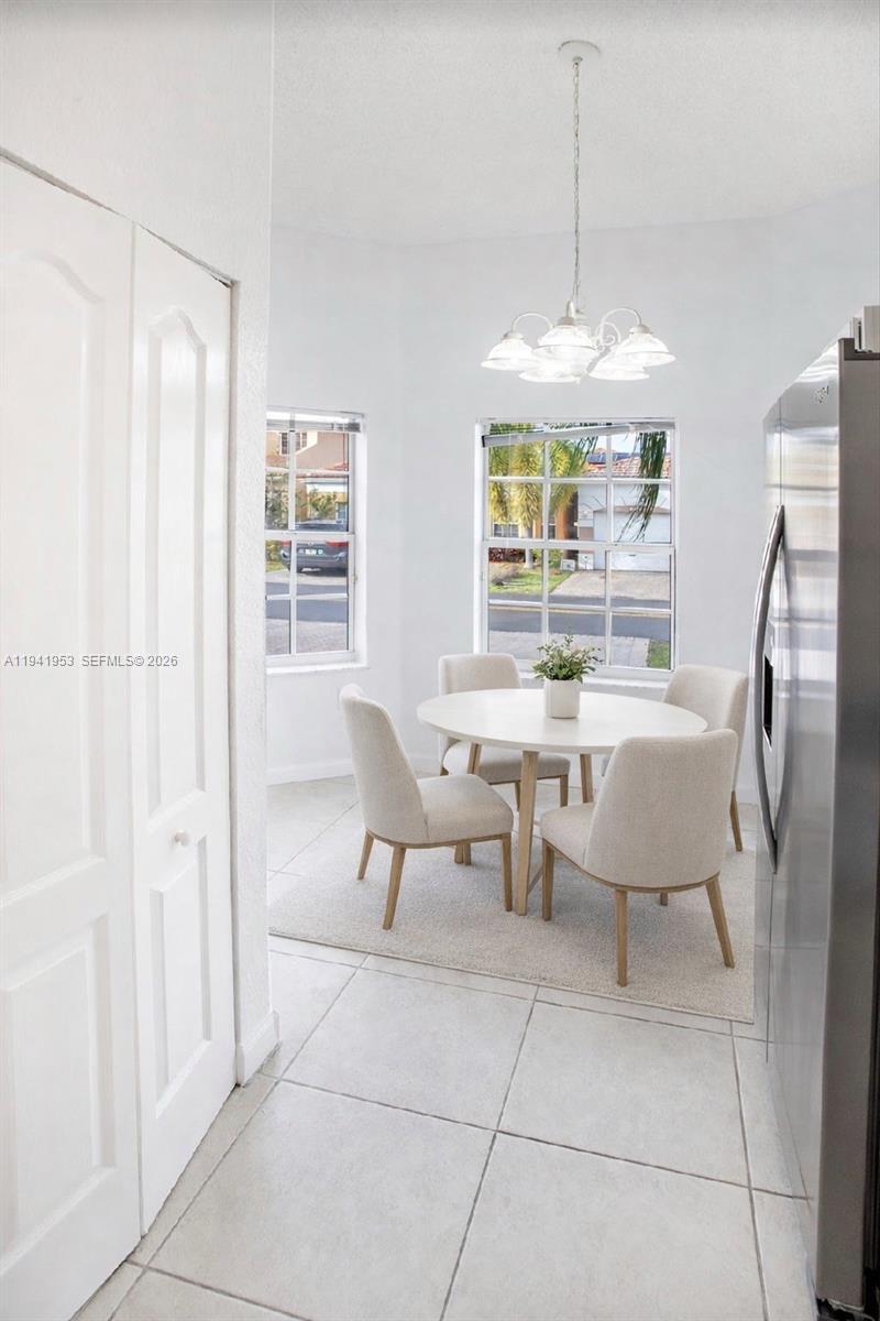 16222 Southwest 102nd Terrace Miami, FL 33196 - Photo 14 of 32 a dining room with furniture a chandelier and window