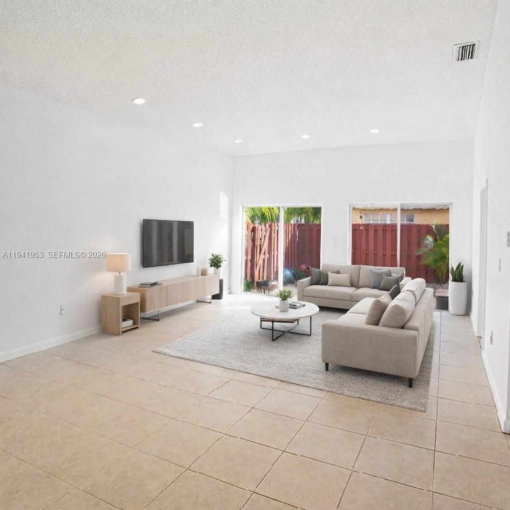 16222 Southwest 102nd Terrace Miami, FL 33196 - Photo 7 of 32 a living room with furniture and a flat screen tv