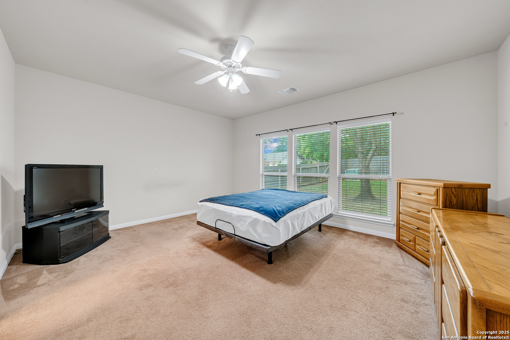 9243 McCafferty Drive Helotes, TX 78023 - Photo 13 of 40 a bedroom with a bed and glass window