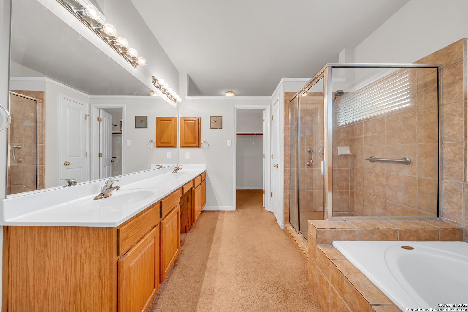 9243 McCafferty Drive Helotes, TX 78023 - Photo 14 of 40 a spacious bathroom with a tub sink shower and mirror