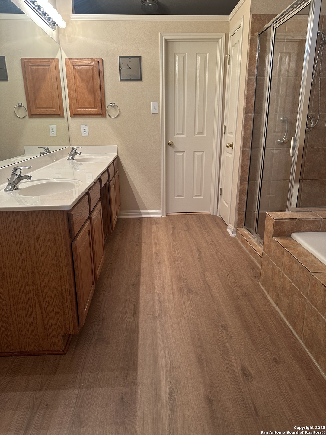 9243 McCafferty Drive Helotes, TX 78023 - Photo 17 of 40 a bathroom with a sink a mirror and a shower