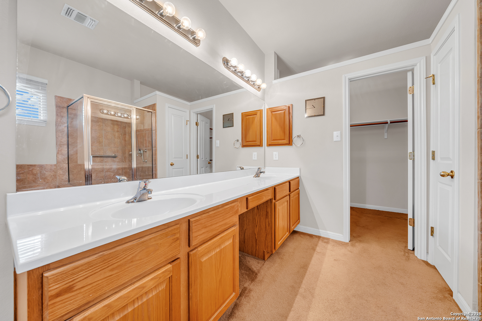 9243 McCafferty Drive Helotes, TX 78023 - Photo 18 of 40 a bathroom with a sink double vanity granite tub shower and a mirror
