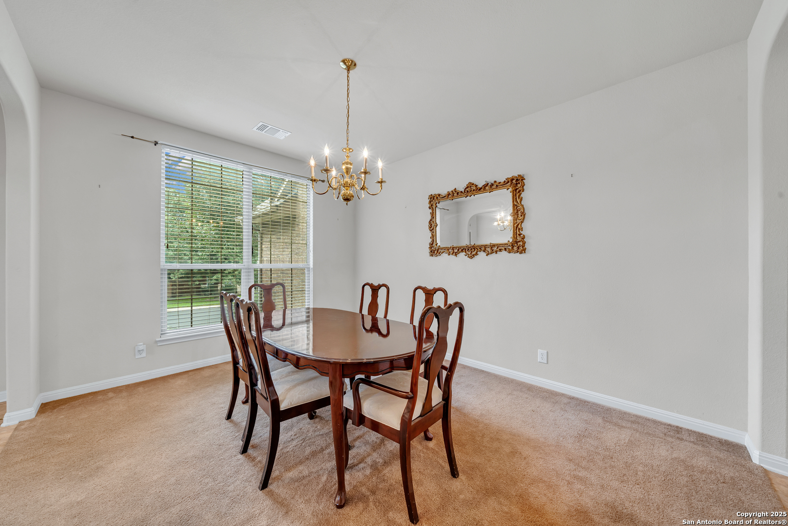 9243 McCafferty Drive Helotes, TX 78023 - Photo 2 of 40 a dining room with furniture a rug and a chandelier