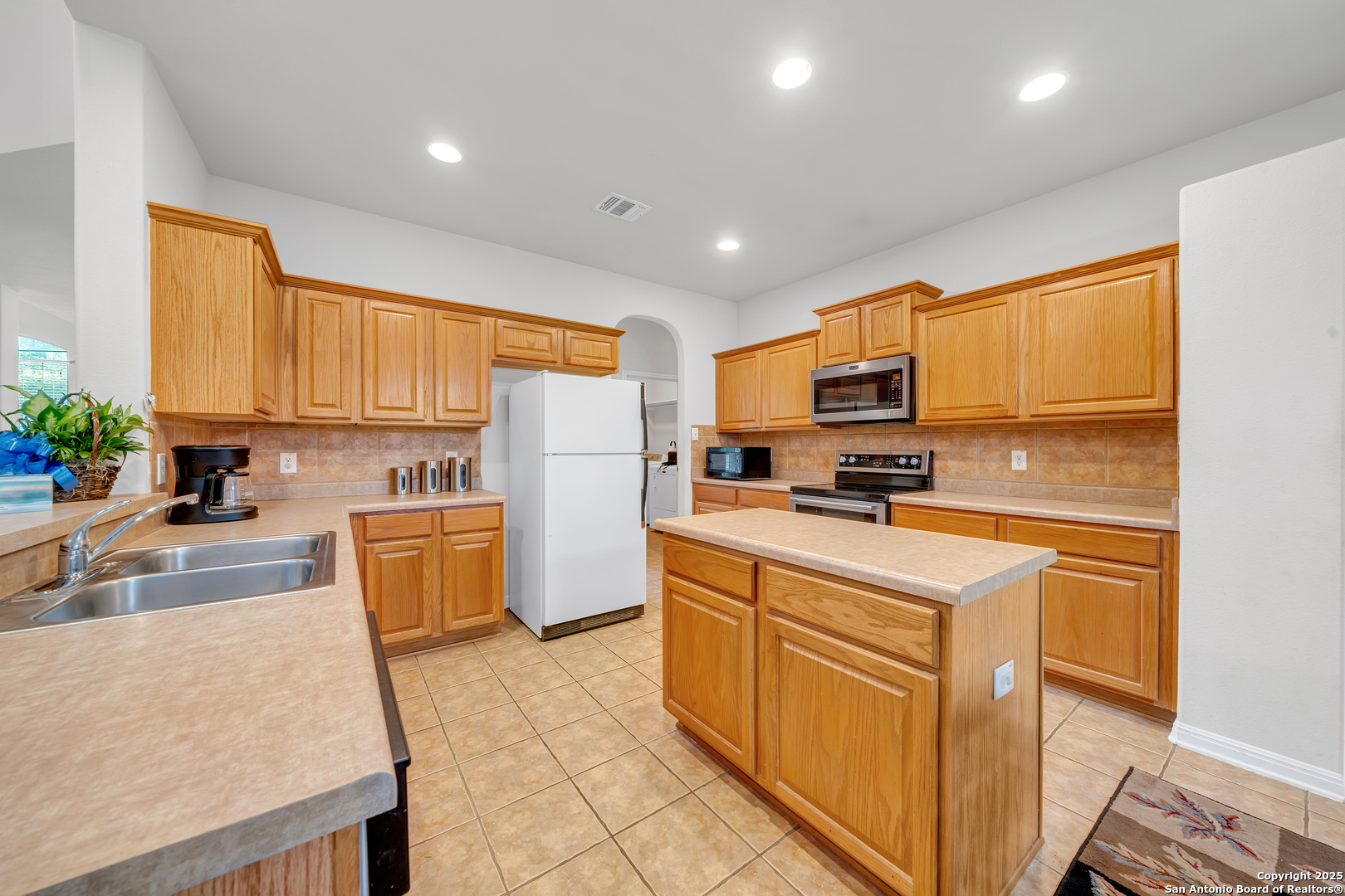 9243 McCafferty Drive Helotes, TX 78023 - Photo 9 of 40 a kitchen with stainless steel appliances a refrigerator sink and cabinets