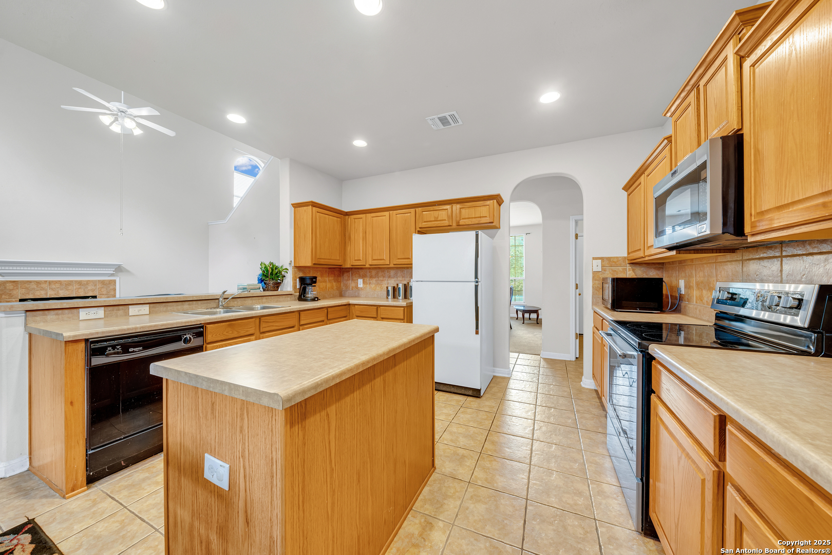 9243 McCafferty Drive Helotes, TX 78023 - Photo 10 of 40 a kitchen with stainless steel appliances a stove a sink and a refrigerator