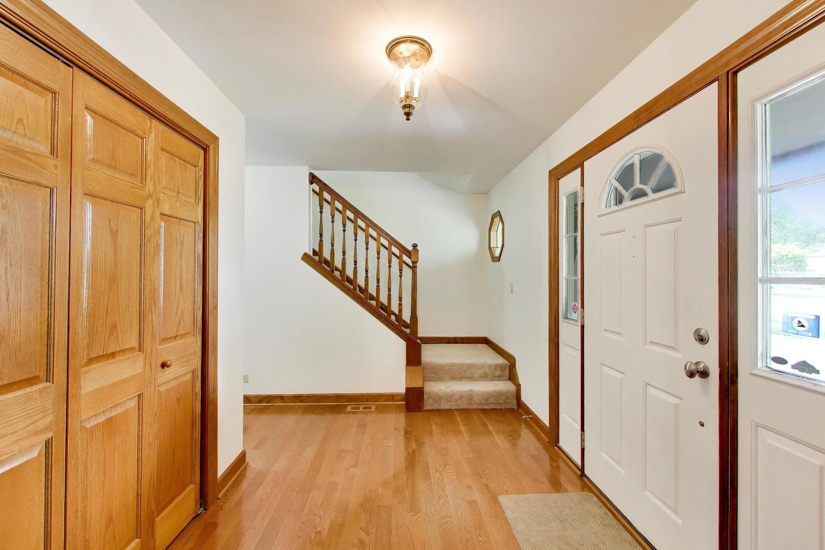 1528 Sequoia Road Naperville, IL 60540 - Photo 5 of 34 a view of a hallway with wooden floor and staircase