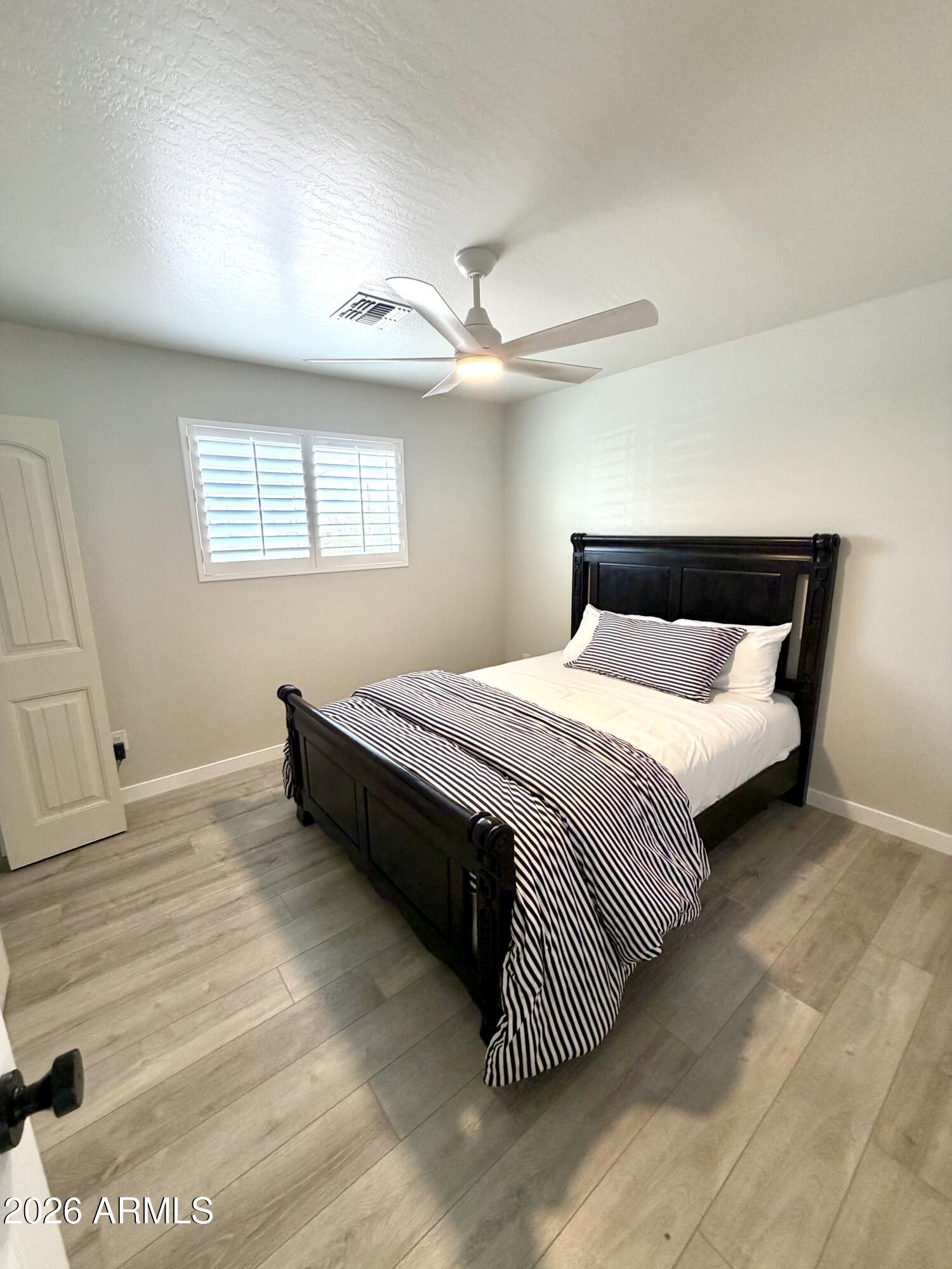 1165 North Mountain View Road Apache Junction, AZ 85119 - Photo 18 of 29 a bedroom with a bed and a ceiling fan
