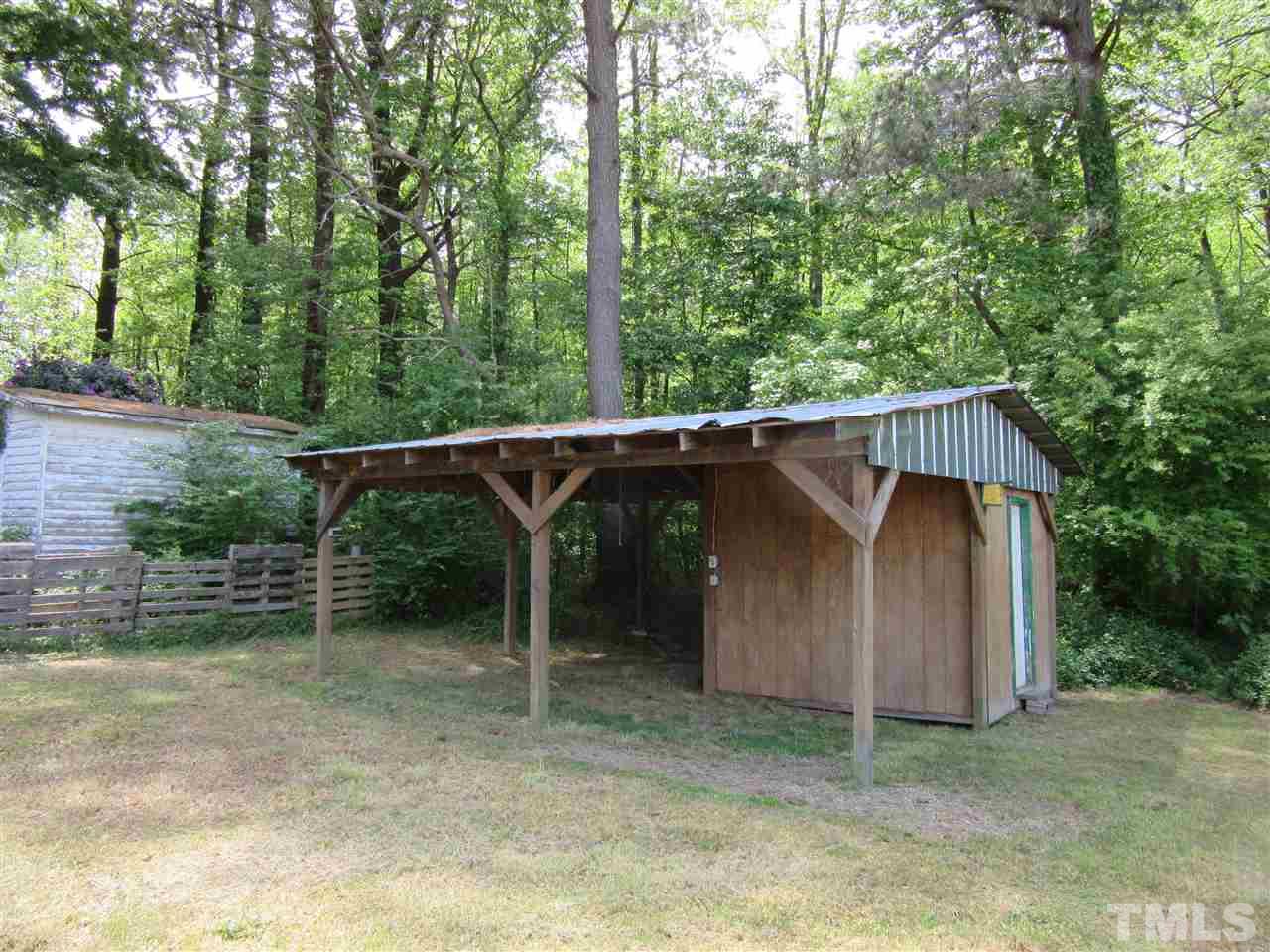 270 Tant Road Zebulon, NC 27597 - Photo 6 of 7 a backyard of a house with lawn chairs plants and large trees