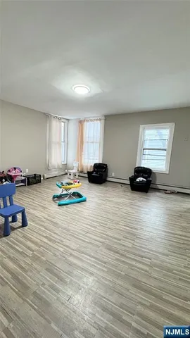 a view of room with gym equipment and wooden floor