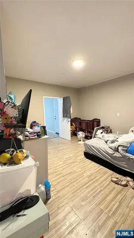 a living room with couches and kitchen view with wooden floor