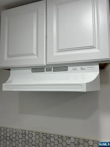 a kitchen with a refrigerator and white cabinets