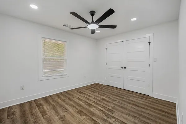 a view of a livingroom with a ceiling fan & hardwood floor