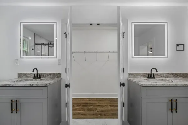 a bathroom with a granite countertop sink and a mirror