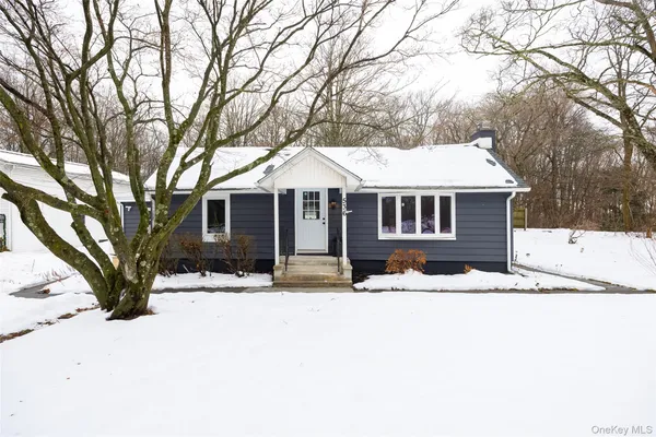a front view of a house with a yard covered in snow