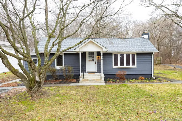 a front view of a house with a yard table and chairs