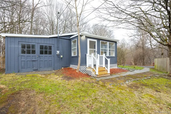 a view of a house with backyard and tree