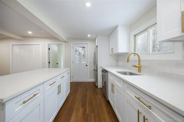 a large kitchen with kitchen island a sink stainless steel appliances and cabinets