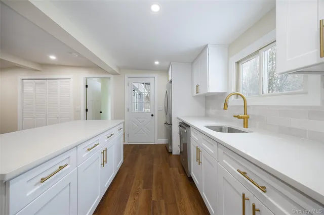 a large kitchen with kitchen island a sink stainless steel appliances and cabinets