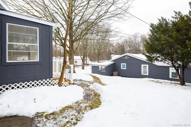 a front view of a house with a yard covered in snow