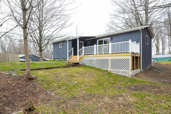 a view of a house with backyard and sitting area