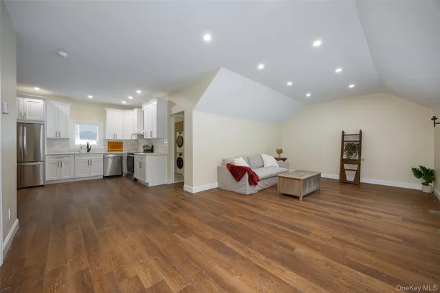a living room with furniture and kitchen view