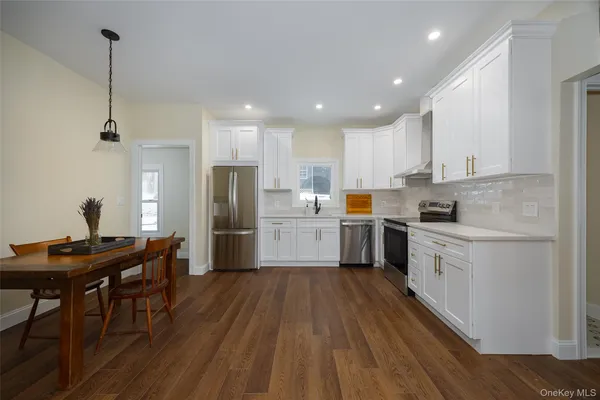a kitchen with white cabinets and stainless steel appliances