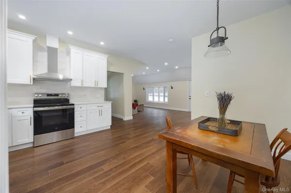 a kitchen with stainless steel appliances a kitchen island hardwood floor sink stove and wooden floor