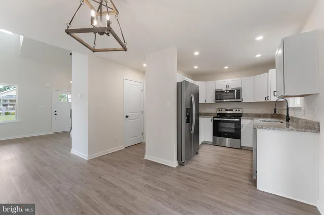 a kitchen with stainless steel appliances granite countertop a refrigerator and a sink