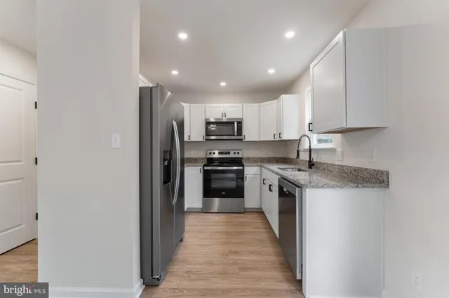 a kitchen with granite countertop stainless steel appliances and refrigerator