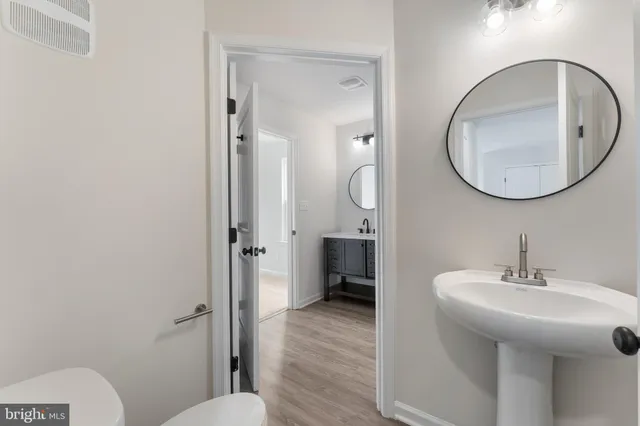 a bathroom with a sink mirror and toilet