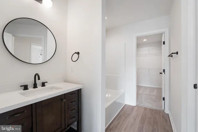 a bathroom with a sink a mirror a vanity and a shower