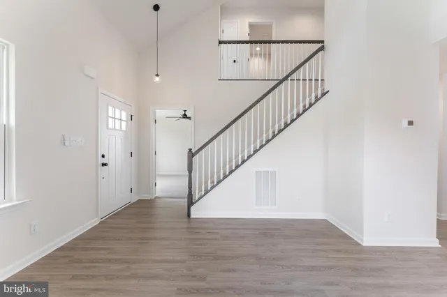 a view of staircase with wooden floor and white walls