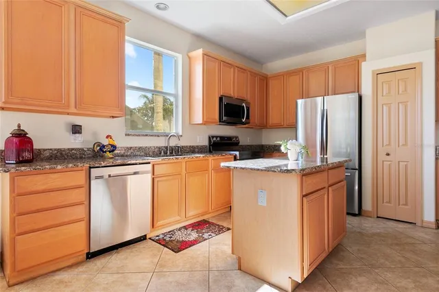 a kitchen with refrigerator a sink a stove and cabinets