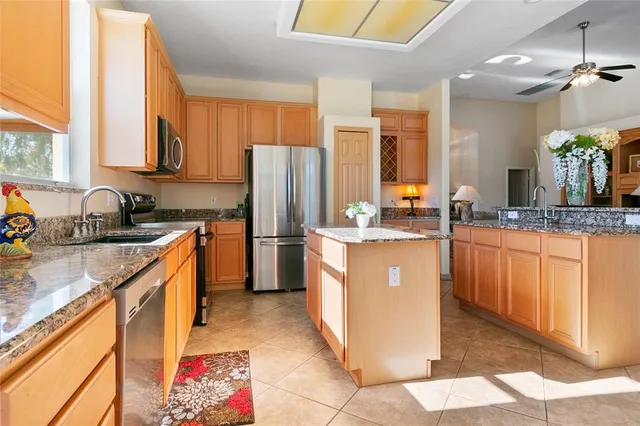 a dining table chairs next to a window and a chandelier