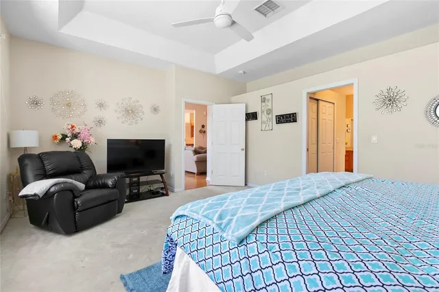 a living room with furniture a flat screen tv and a floor to ceiling window