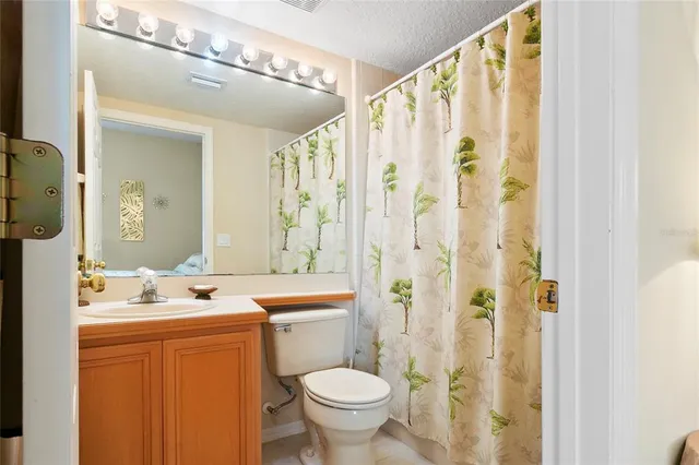 a bedroom with a bed a painting on the wall and a window