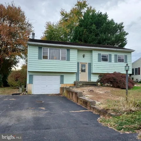 a view of a house with backyard and trees