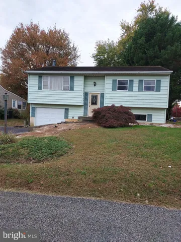 a view of a house with backyard and trees