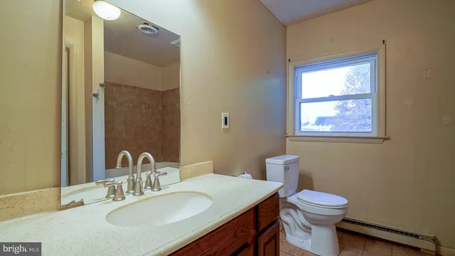 a bathroom with a toilet sink vanity and mirror