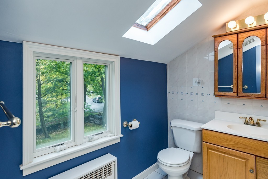 41 Watertown Street Lexington, MA 02421 - Photo 18 of 23 a bathroom with a toilet a sink a mirror and a window