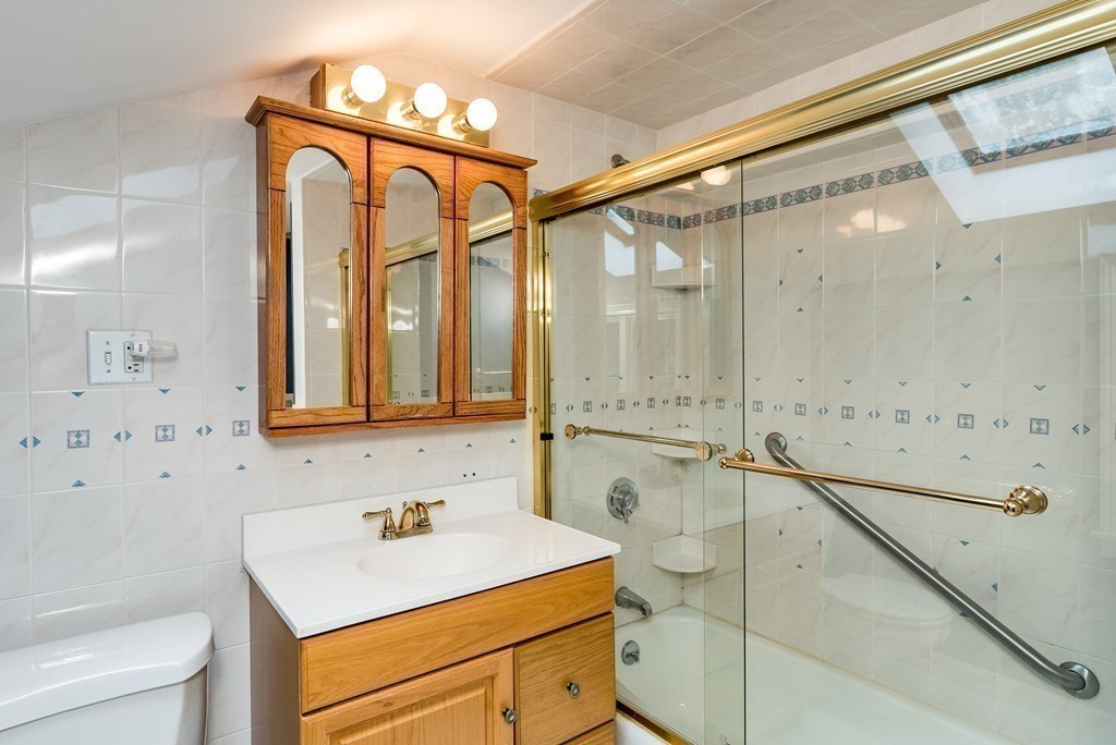 41 Watertown Street Lexington, MA 02421 - Photo 19 of 23 a bathroom with a sink a toilet and a mirror