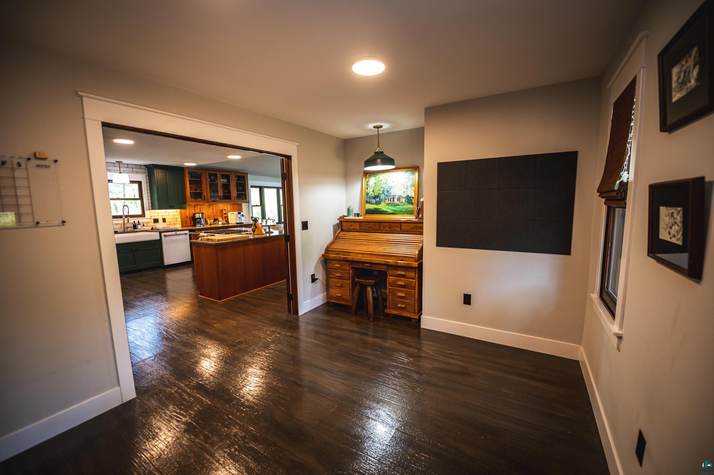 14635 Canadian Border Road Ely, MN 55731 - Photo 82 of 94 Wood-finish flooring throughout, featuring a kitchen with a double basin sink, green and wood cabinetry, and a central island
