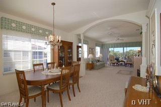 10751 Halfmoon Shoal Road, Unit 201 Bonita Springs, FL 34135 - Photo 4 of 8 a view of a dining room and livingroom with furniture wooden floor a chandelier