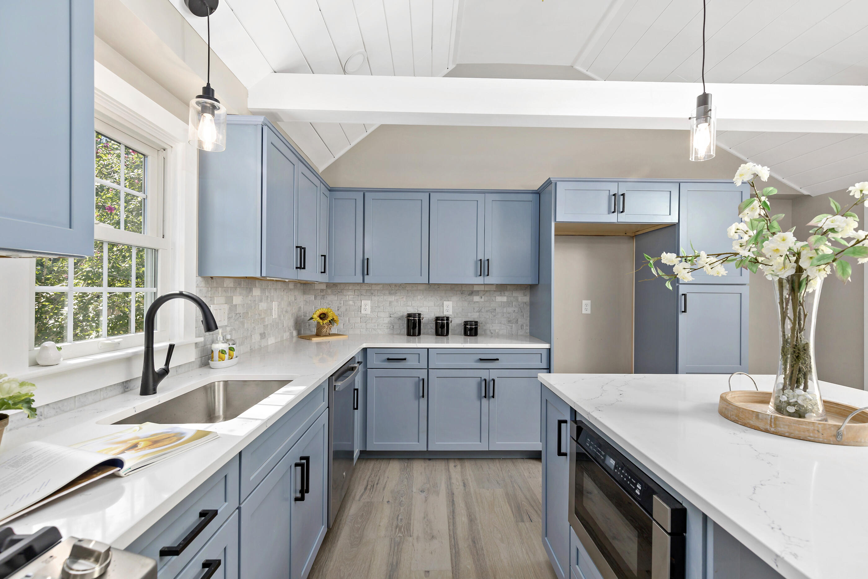 53 Monument Neck Road Bourne, MA 02532 - Photo 17 of 44 a kitchen with a sink dishwasher a stove a microwave oven with potted plants