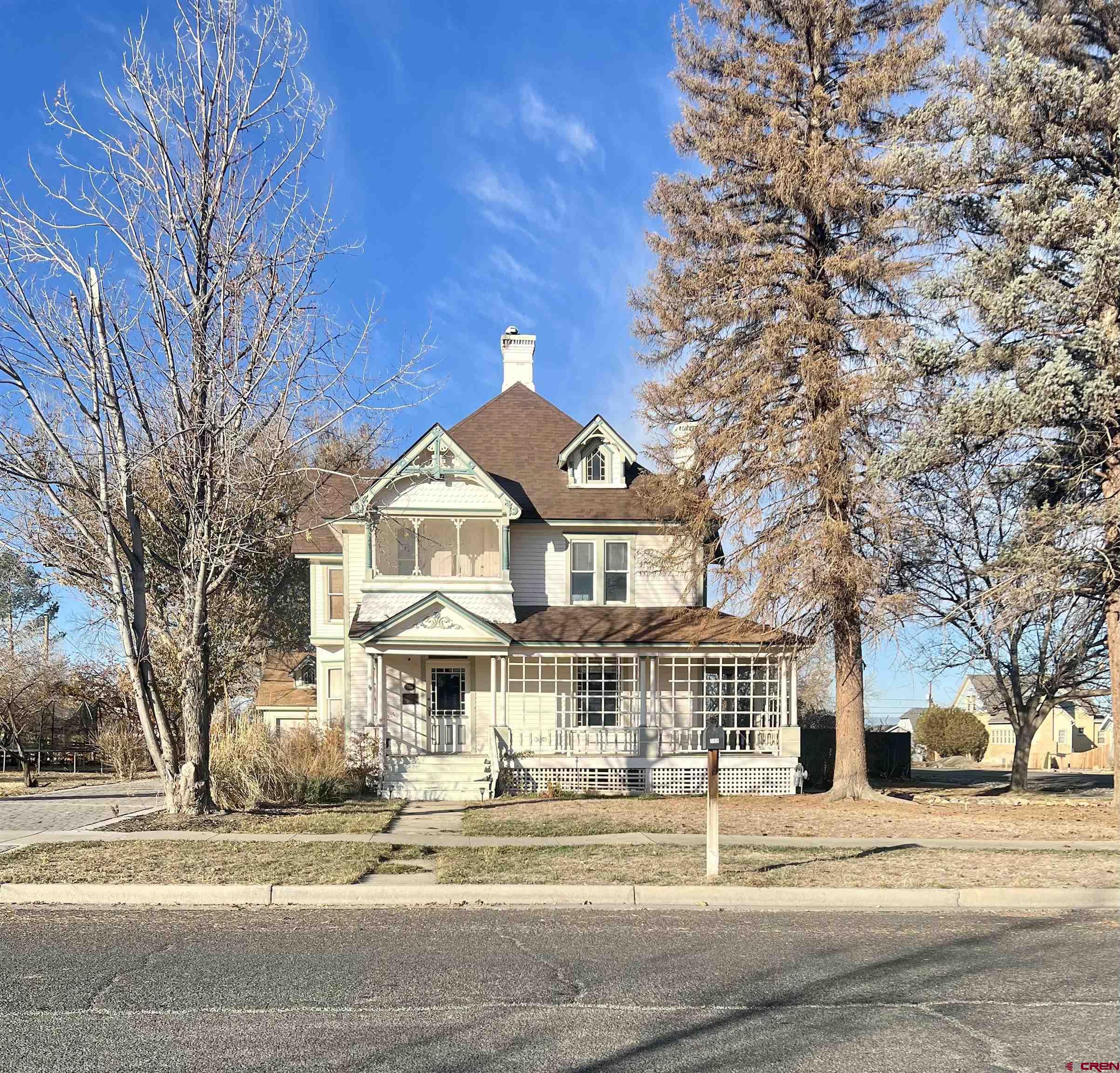 a front view of residential houses with yard and trees