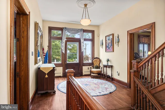 a view of house in front of a big yard with large trees and plants