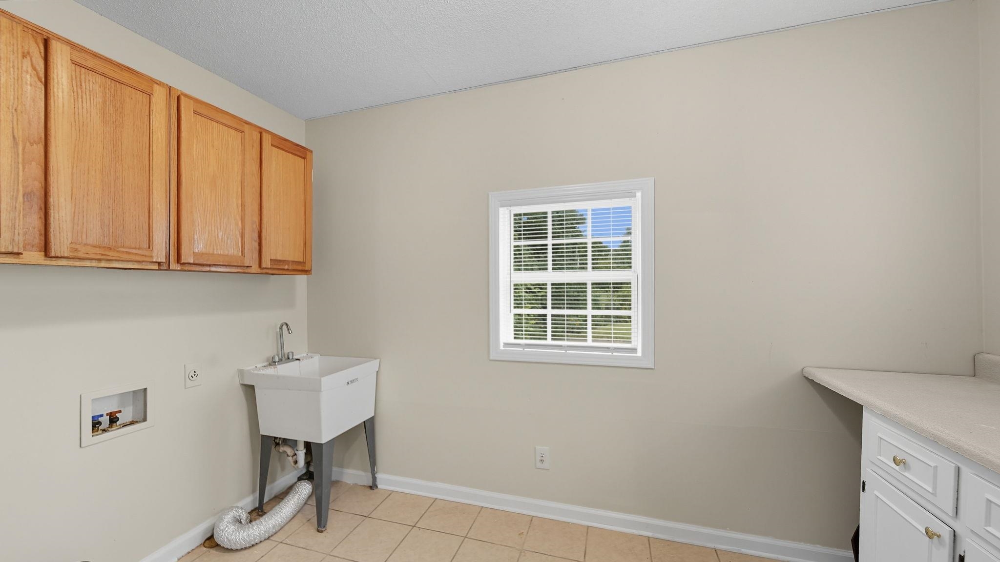 1503 Beaver Road Munford, TN 38058 - Photo 13 of 29 a bathroom with a sink a light fixture and a window