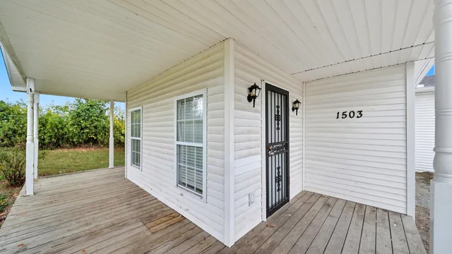 a view of a porch with wooden floor and floor to ceiling window