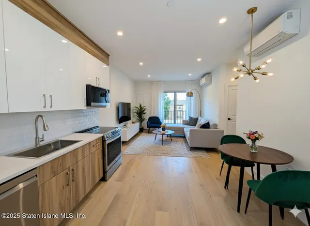 a large kitchen with kitchen island a white counter space a sink stainless steel appliances and cabinets